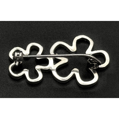 140 - An 18K White Gold and Diamond Brooch. Graduated encrusted stars. 3cm. 4.7g total weight.