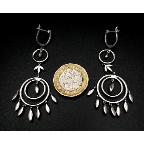 21 - A pair of Art Deco Style Pair of 18K White Gold and Diamond Drop Earrings. A multitude of diamond en... 