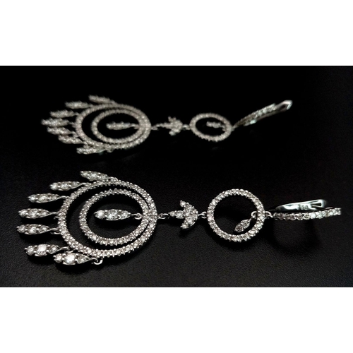 21 - A pair of Art Deco Style Pair of 18K White Gold and Diamond Drop Earrings. A multitude of diamond en... 