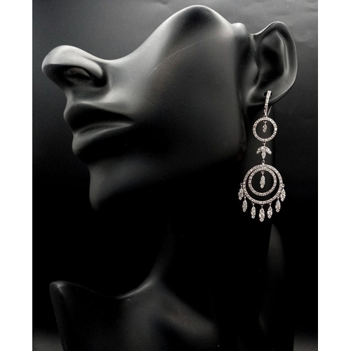 21 - A pair of Art Deco Style Pair of 18K White Gold and Diamond Drop Earrings. A multitude of diamond en... 