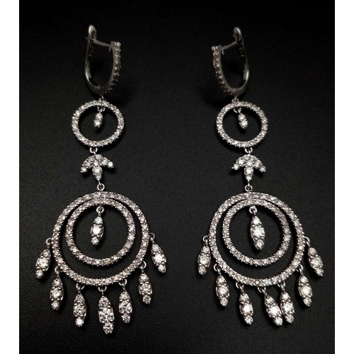 21 - A pair of Art Deco Style Pair of 18K White Gold and Diamond Drop Earrings. A multitude of diamond en... 