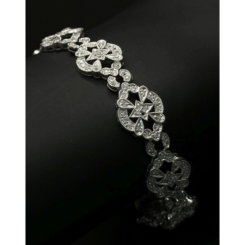 189 - An Art Deco Style 14K White Gold and Diamond Bracelet. 18cm. 10.9g. Five small stones missing so A/F... 