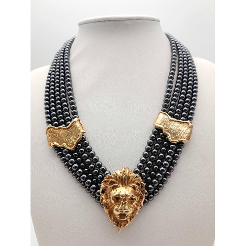 126 - A 9K Gold Clasped Lion's Head Five Row Haematite Necklace. 
44cm.