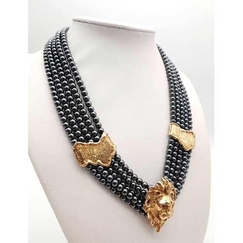 126 - A 9K Gold Clasped Lion's Head Five Row Haematite Necklace. 
44cm.