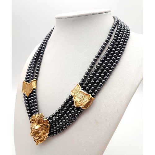 126 - A 9K Gold Clasped Lion's Head Five Row Haematite Necklace. 
44cm.
