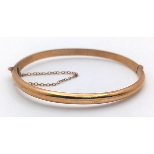 244 - A Vintage 9K Yellow Gold Bangle. Clip design and safety chain. 6.7g.