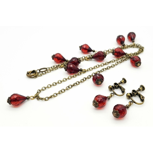 762 - A clear faceted cherry amber resin link necklace, paired with a matching earrings set. 49cm chain le... 