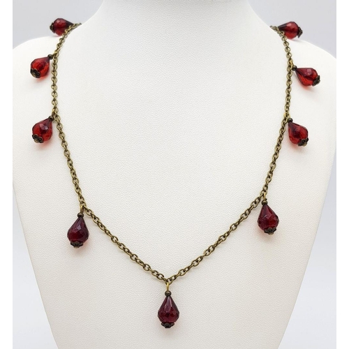 762 - A clear faceted cherry amber resin link necklace, paired with a matching earrings set. 49cm chain le... 