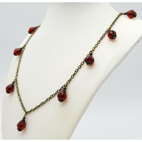 762 - A clear faceted cherry amber resin link necklace, paired with a matching earrings set. 49cm chain le... 