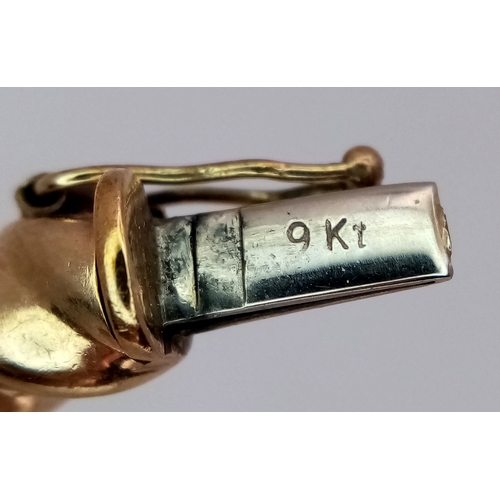 6 - A 9K Yellow Gold Decorative Ridged Bangle. Clip-open design. 6cm inner diameter. 14.85g