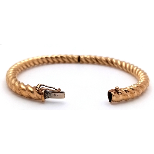 6 - A 9K Yellow Gold Decorative Ridged Bangle. Clip-open design. 6cm inner diameter. 14.85g