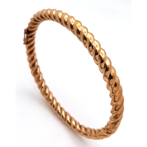 6 - A 9K Yellow Gold Decorative Ridged Bangle. Clip-open design. 6cm inner diameter. 14.85g