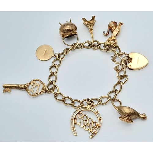 693 - A 9K GOLD CHARM BRACELET WITH 7 CHARMS TO INCLUDE A GOOD LUCK HORSESHOE,THE EIFFEL TOWER , A NICE CU... 