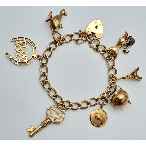 693 - A 9K GOLD CHARM BRACELET WITH 7 CHARMS TO INCLUDE A GOOD LUCK HORSESHOE,THE EIFFEL TOWER , A NICE CU... 