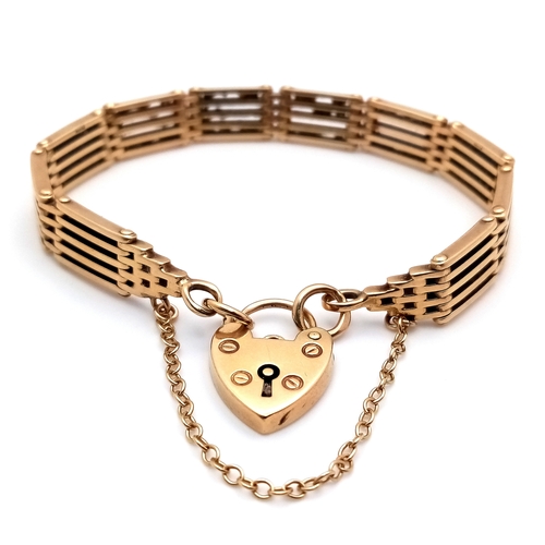 700 - A Well Constructed 9K Yellow Gold Gate Bracelet with Heart Charm and Safety Chain. 16cm. 28.75g
