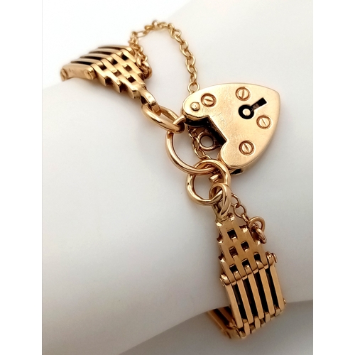 700 - A Well Constructed 9K Yellow Gold Gate Bracelet with Heart Charm and Safety Chain. 16cm. 28.75g