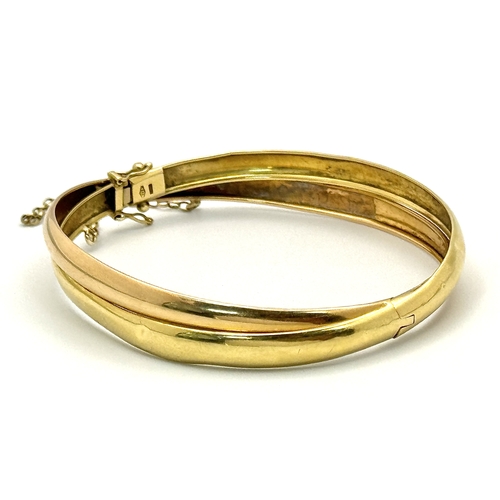 721 - A Vintage 18K Yellow Gold Bangle. Clip design. Safety chain. 15.4g.