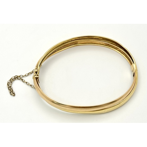 721 - A Vintage 18K Yellow Gold Bangle. Clip design. Safety chain. 15.4g.