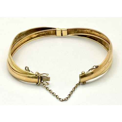721 - A Vintage 18K Yellow Gold Bangle. Clip design. Safety chain. 15.4g.