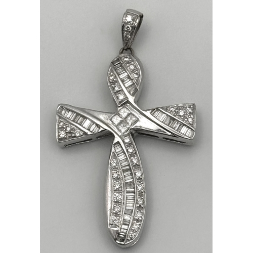 784 - A 14K White Gold Diamond Set Cross Pendant. A combination of tapered baguette, round and princess cu... 
