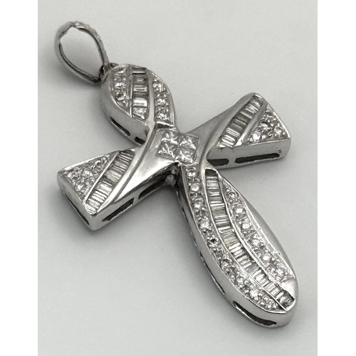 784 - A 14K White Gold Diamond Set Cross Pendant. A combination of tapered baguette, round and princess cu... 