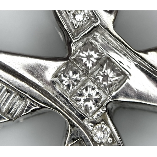 784 - A 14K White Gold Diamond Set Cross Pendant. A combination of tapered baguette, round and princess cu... 