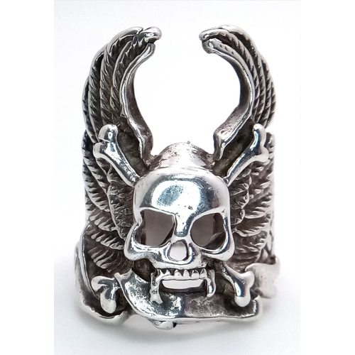 726 - A STERLING SILVER SKULL, CROSSBONES AND WINGS RING. 12.3G. SIZE S. SC5012.