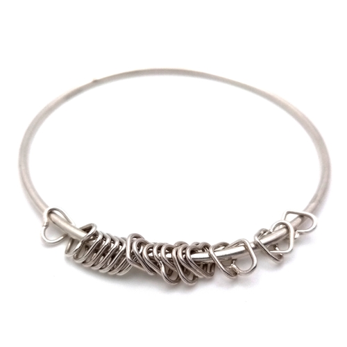 740 - A STERLING SILVER BANGLE WITH HEART CHARMS ATTACHED 9.6G TOTAL WEIGHT, 7.2CM DIAMETER. REF: TAN 5004
