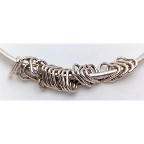 740 - A STERLING SILVER BANGLE WITH HEART CHARMS ATTACHED 9.6G TOTAL WEIGHT, 7.2CM DIAMETER. REF: TAN 5004