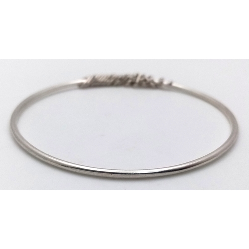 740 - A STERLING SILVER BANGLE WITH HEART CHARMS ATTACHED 9.6G TOTAL WEIGHT, 7.2CM DIAMETER. REF: TAN 5004