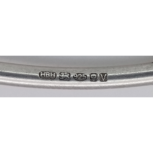 740 - A STERLING SILVER BANGLE WITH HEART CHARMS ATTACHED 9.6G TOTAL WEIGHT, 7.2CM DIAMETER. REF: TAN 5004