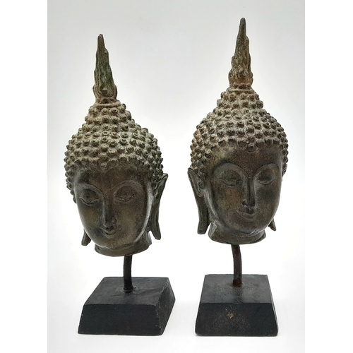 729 - A Pair of Antique SE Asian Bronze Buddha Head Figures. Both on wooden stands. 19cm.