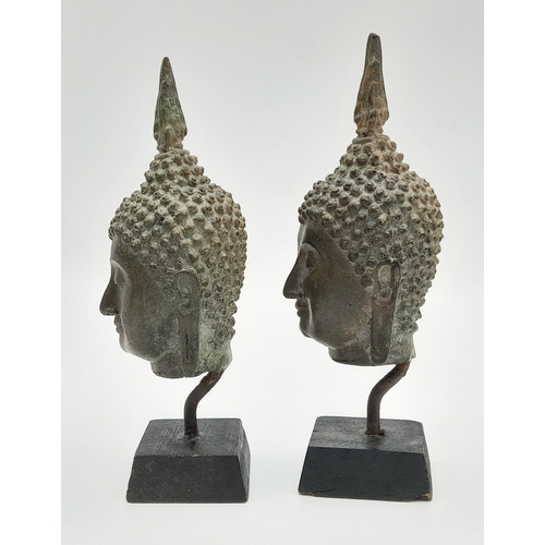 729 - A Pair of Antique SE Asian Bronze Buddha Head Figures. Both on wooden stands. 19cm.