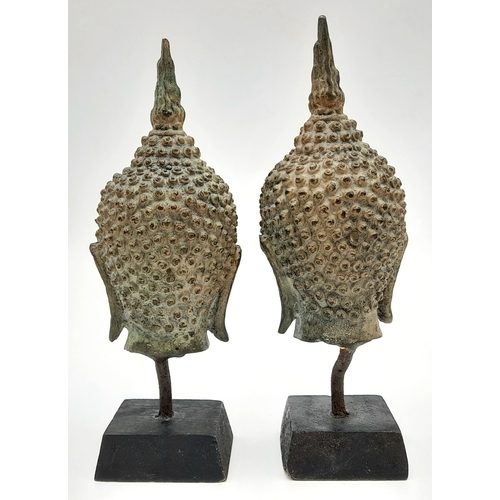 729 - A Pair of Antique SE Asian Bronze Buddha Head Figures. Both on wooden stands. 19cm.