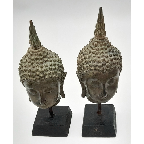 729 - A Pair of Antique SE Asian Bronze Buddha Head Figures. Both on wooden stands. 19cm.