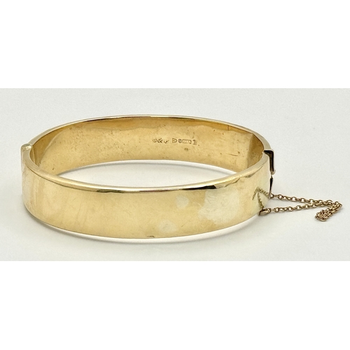 1212 - A Vintage 9K Yellow Gold Bangle. 14mm width. Chester hallmarks. A few dents and minor discolouration... 