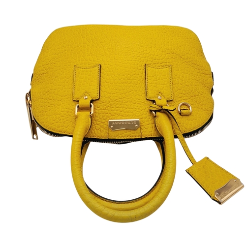 187 - A Burberry Yellow Leather Dome Tote Bag. Yellow leather exterior with gold-toned hardware, dual roll... 