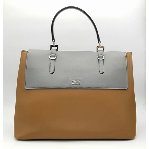 229 - A Prada Milano Two-Tone Leather Tote Bag. Grey and tan smooth leather exterior with silver-toned har... 