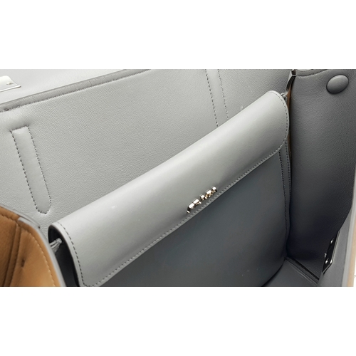 229 - A Prada Milano Two-Tone Leather Tote Bag. Grey and tan smooth leather exterior with silver-toned har... 