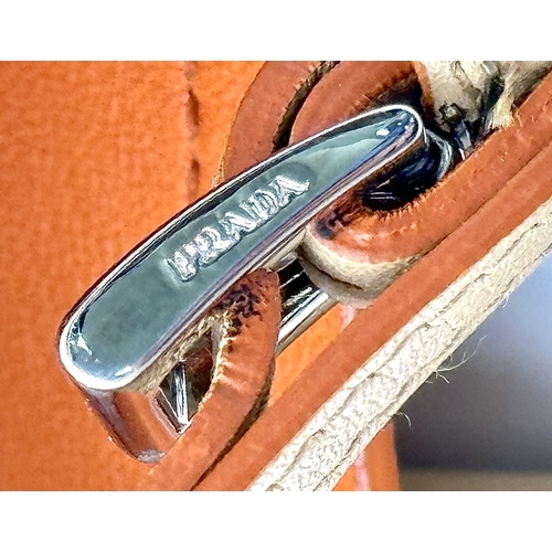 201 - A Prada Beige and Orange Leather Tote Bag. Beige leather exterior with gold-toned hardware, dual rol... 