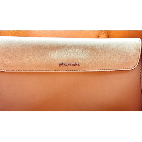 201 - A Prada Beige and Orange Leather Tote Bag. Beige leather exterior with gold-toned hardware, dual rol... 