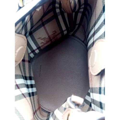 222 - A Burberry Brown Leather Bucket Bag. Brown leather exterior with gold-toned hardware and an adjustab... 