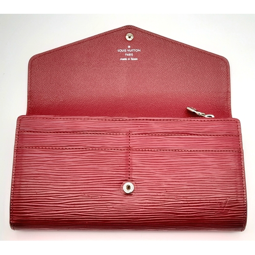 194 - A Louis Vuitton Epi Sarah Wallet. Purple Epi leather exterior with silver-toned hardware and a patch... 