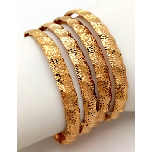 121 - A 9k yellow gold lot of 4 bangles. 6cm diameter, 12.3g total weight./ SH1986I.