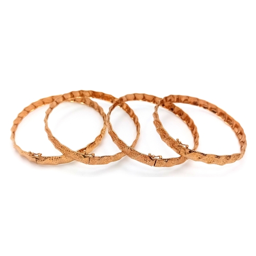 121 - A 9k yellow gold lot of 4 bangles. 6cm diameter, 12.3g total weight./ SH1986I.
