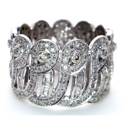 47 - An 18K White Gold and Diamond Regal-Esque Ring. Crown form, with baguette and round cut diamonds thr... 