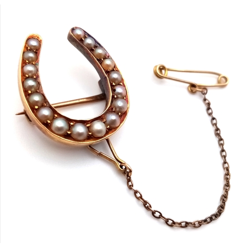 136 - An Antique 9K Gold and Pearl Horseshoe Brooch with Safety Chain. 2.2cm. 3.4g total weight.