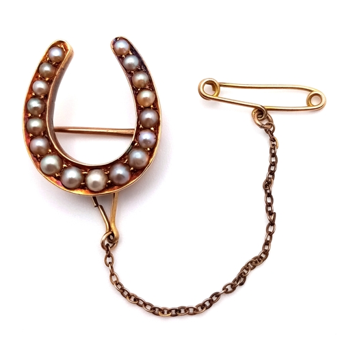 136 - An Antique 9K Gold and Pearl Horseshoe Brooch with Safety Chain. 2.2cm. 3.4g total weight.