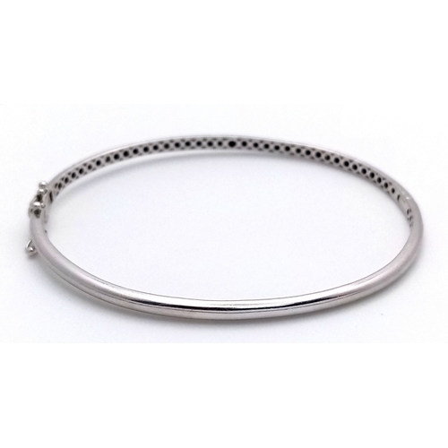 19 - AN 18K WHITE GOLD DIAMOND SET BANGLE. 9.1G. SC-1070
