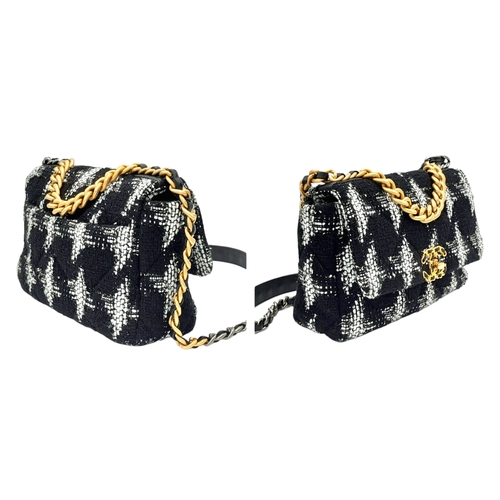 34 - A Chanel Black and White Tweed Flap Bag. Quilted tweed exterior with gold toned hardware, leather-in... 